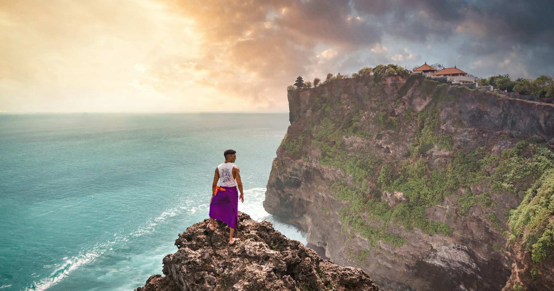 Backpacker looking out over the sea from a clifftop in Bali, Indonesia