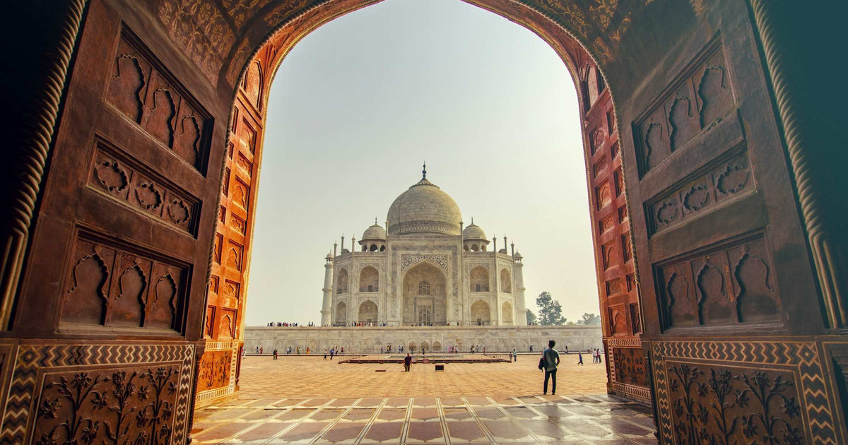 Taj Mahal seen through an ornate Mughal archway in Agra, India