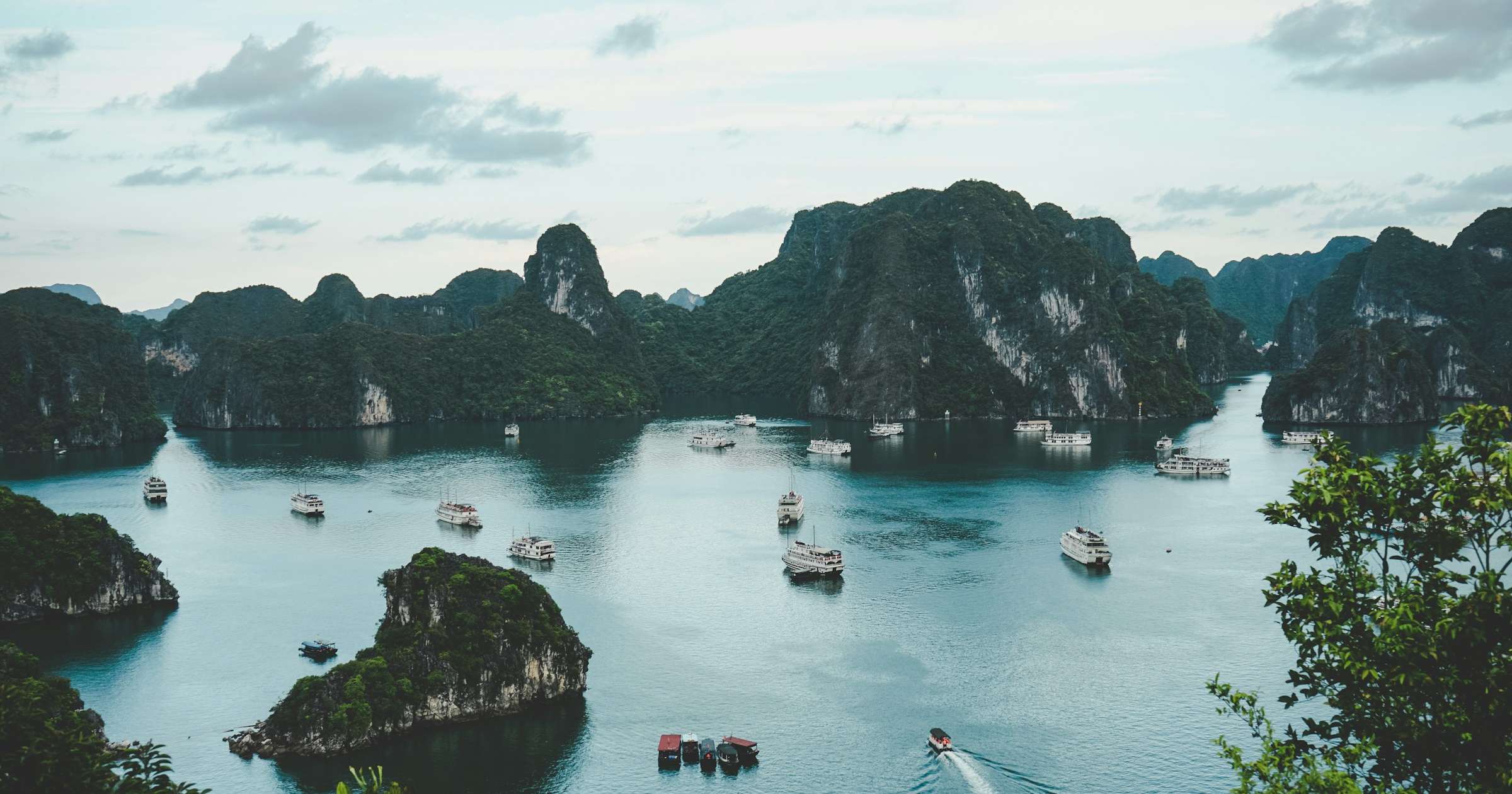 Aerial view of Ha Long Bay, Vietnam, showing limestone karsts and cruise boats on turquoise water