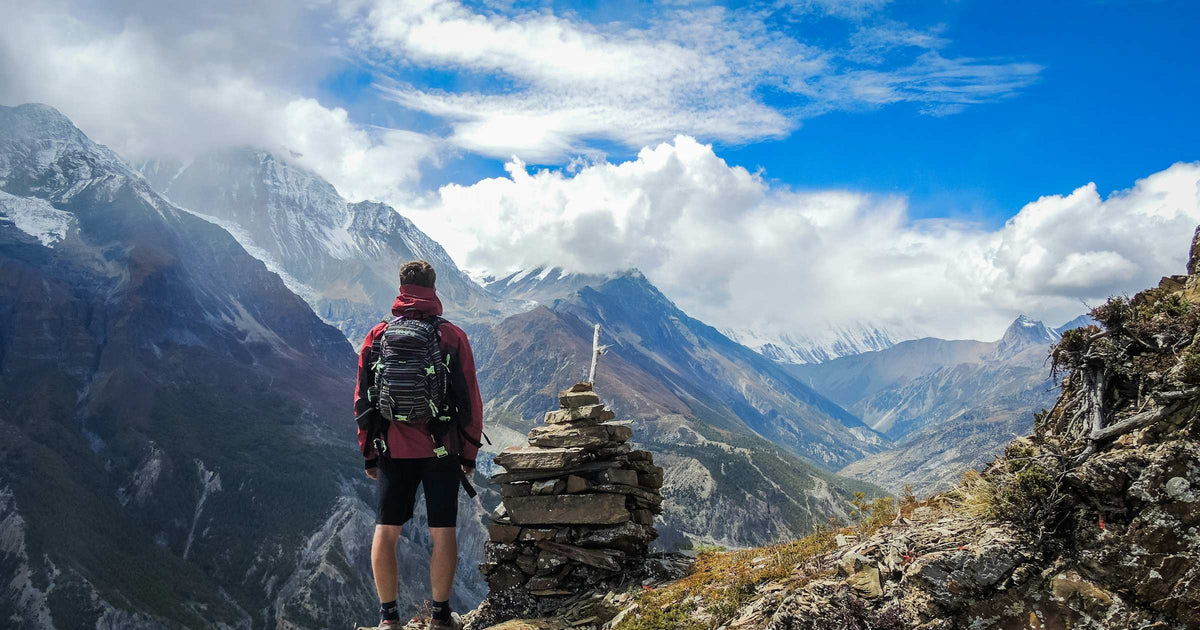 Trekker with backpack overlooking a Himalayan valley in Nepal during the Annapurna Circuit trek