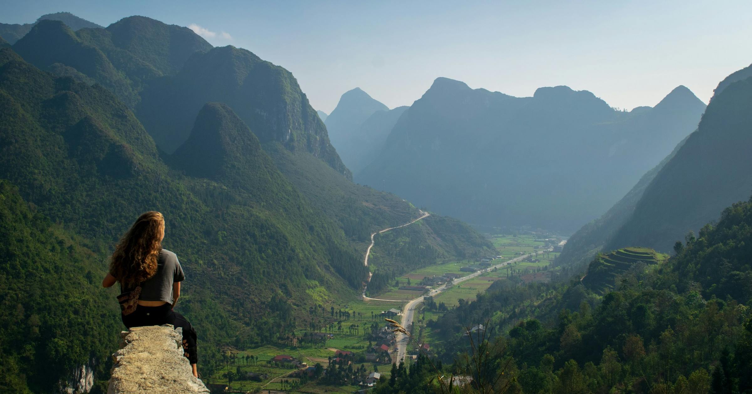 Solo female traveller overlooking a mountain valley in Southeast Asia